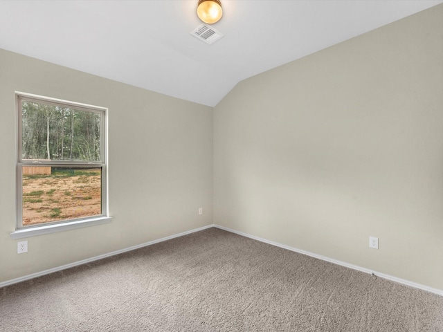 carpeted spare room with vaulted ceiling, visible vents, and baseboards