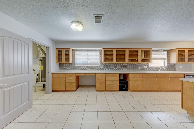 kitchen with visible vents, light countertops, backsplash, open shelves, and built in desk