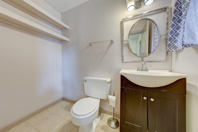 half bathroom with tile patterned flooring, baseboards, vanity, and toilet