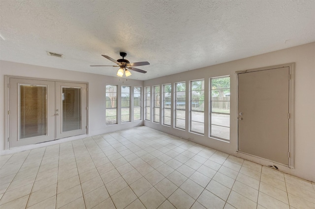 unfurnished sunroom with french doors, visible vents, and a ceiling fan