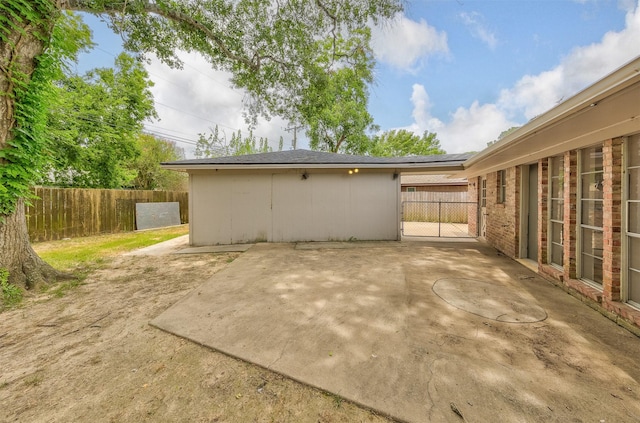 exterior space with a patio area, fence, and brick siding