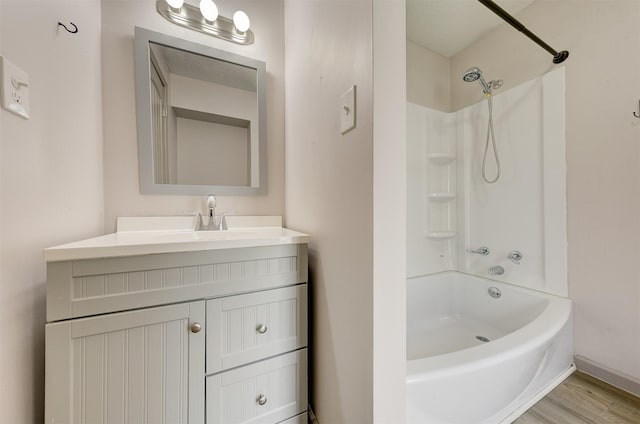 full bath with shower / bathtub combination, wood finished floors, and vanity