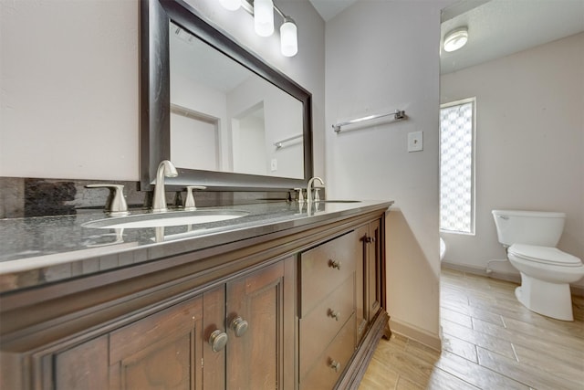 bathroom featuring a wealth of natural light, a sink, and toilet