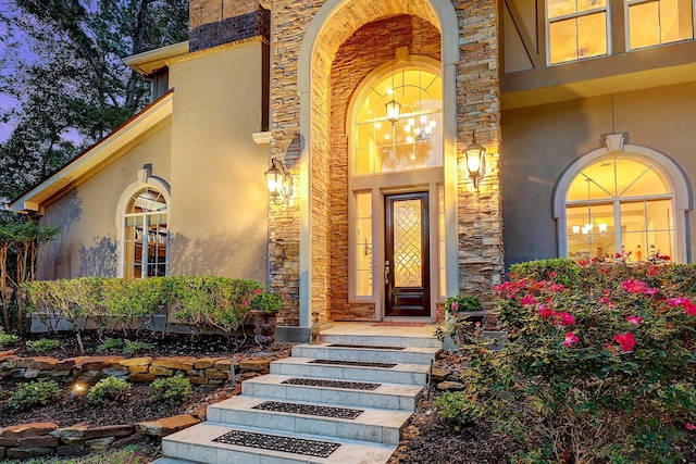 37314 Edgewater Dr, Pinehurst, TX 77362 - view of exterior entry with stucco siding, stone siding, and a porch