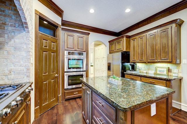 37314 Edgewater Dr, Pinehurst, TX 77362 - kitchen featuring stainless steel appliances, arched walkways, crown molding, tasteful backsplash, and dark wood finished floors
