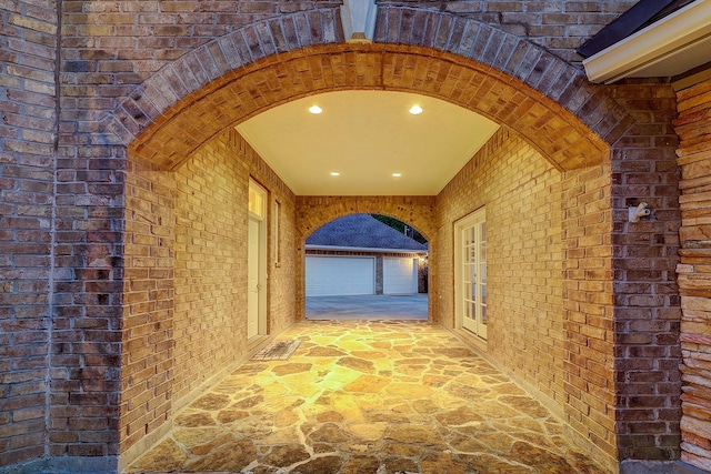 37314 Edgewater Dr, Pinehurst, TX 77362 - corridor with brick wall, stone floors, arched walkways, and recessed lighting