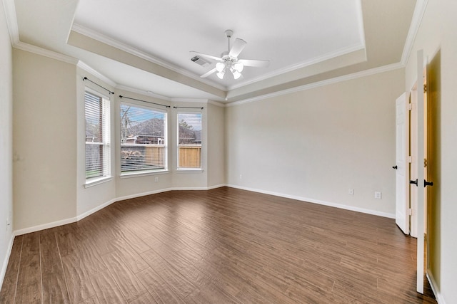 unfurnished room with a tray ceiling, dark wood finished floors, visible vents, and baseboards