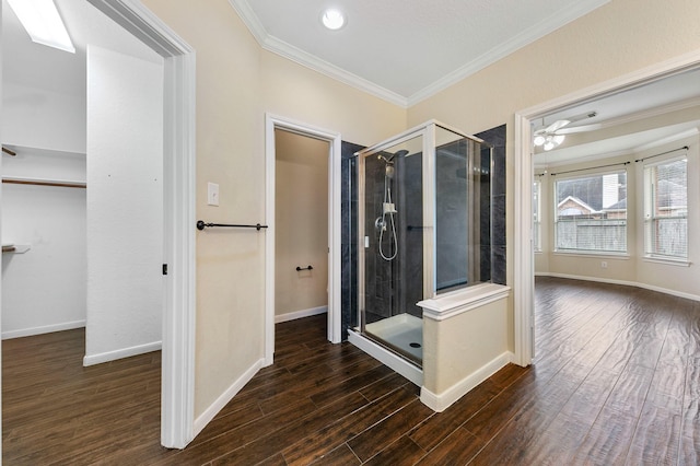 full bathroom featuring ornamental molding, wood finished floors, and a shower stall