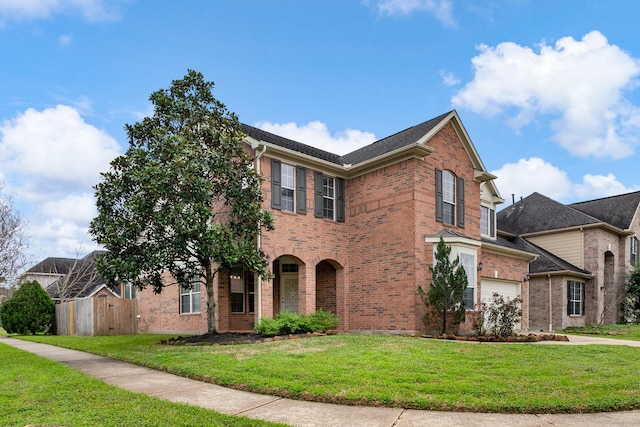 view of front of property featuring a garage, brick siding, and a front yard