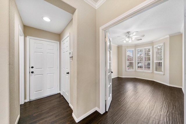 foyer entrance with baseboards, ornamental molding, and dark wood-type flooring