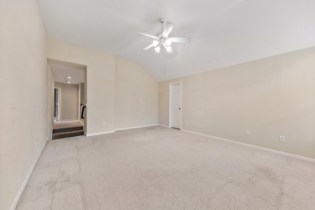 spare room featuring ceiling fan, baseboards, vaulted ceiling, and carpet flooring