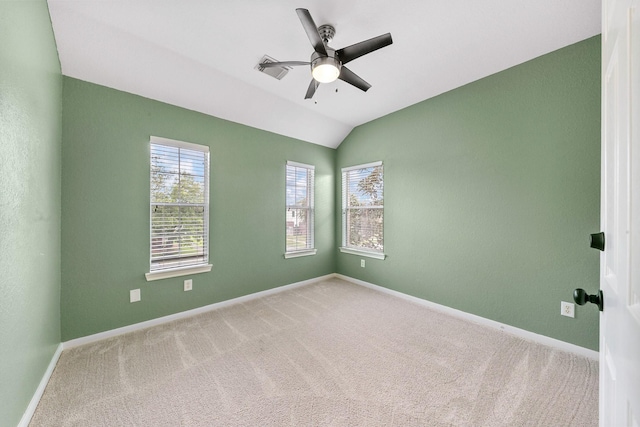 carpeted spare room with lofted ceiling, ceiling fan, and baseboards