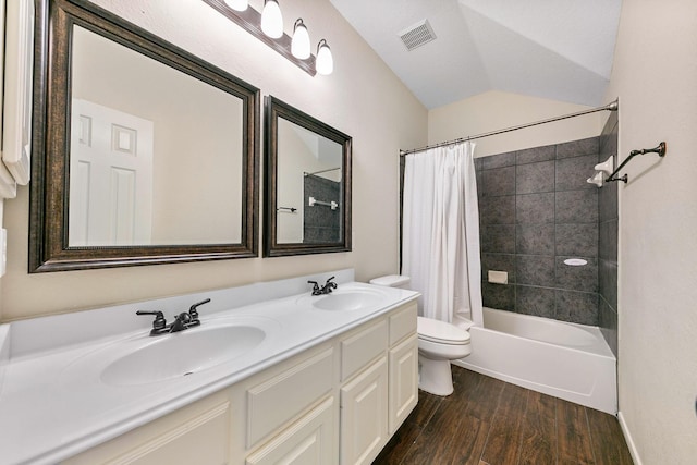 full bath featuring a sink, visible vents, vaulted ceiling, and wood finished floors