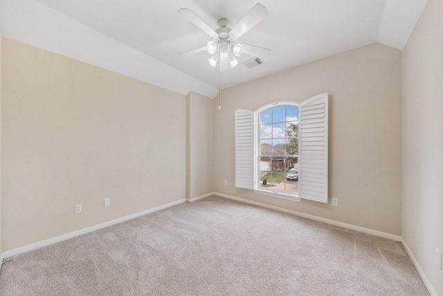 carpeted empty room featuring visible vents, baseboards, vaulted ceiling, and a ceiling fan