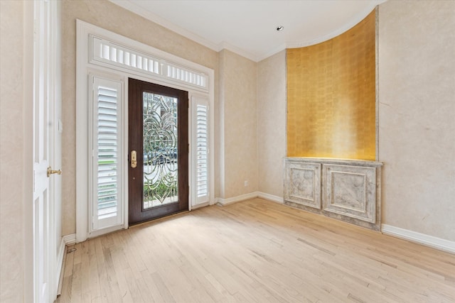 foyer entrance featuring crown molding, baseboards, and wood finished floors