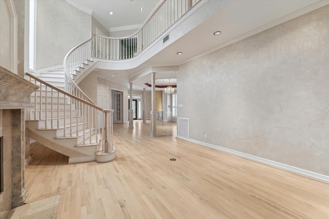 foyer with a high ceiling, wood finished floors, visible vents, and baseboards