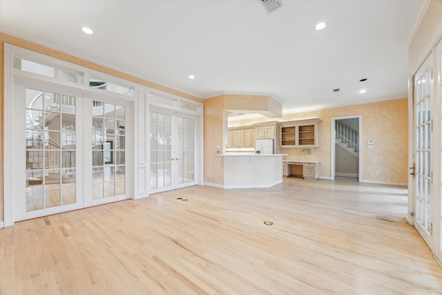 unfurnished living room with visible vents, stairway, crown molding, french doors, and light wood-style floors