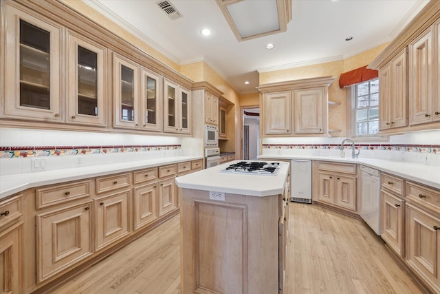 kitchen featuring white appliances, light wood-type flooring, light brown cabinets, and visible vents