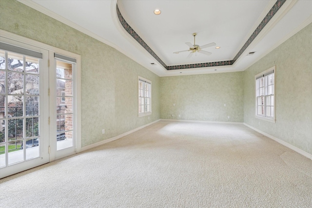 carpeted empty room with visible vents, baseboards, a raised ceiling, a ceiling fan, and recessed lighting