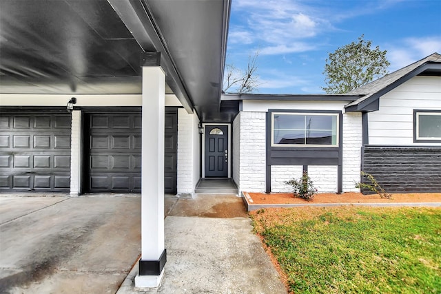 doorway to property with concrete driveway and brick siding