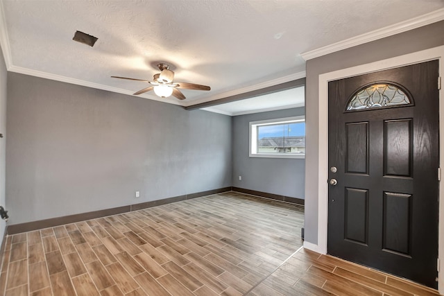 foyer entrance featuring wood finish floors, crown molding, a textured ceiling, and baseboards