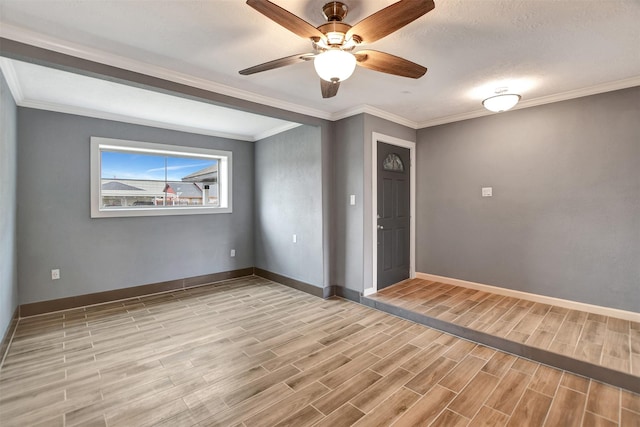 empty room featuring ornamental molding, wood finish floors, and baseboards