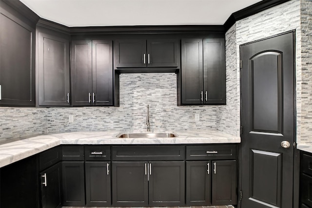 kitchen featuring tasteful backsplash, a sink, and light stone counters