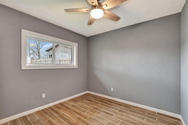 unfurnished room with a ceiling fan, wood tiled floor, and baseboards