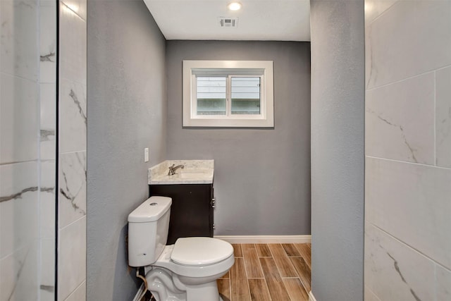 full bath featuring visible vents, baseboards, toilet, wood tiled floor, and vanity