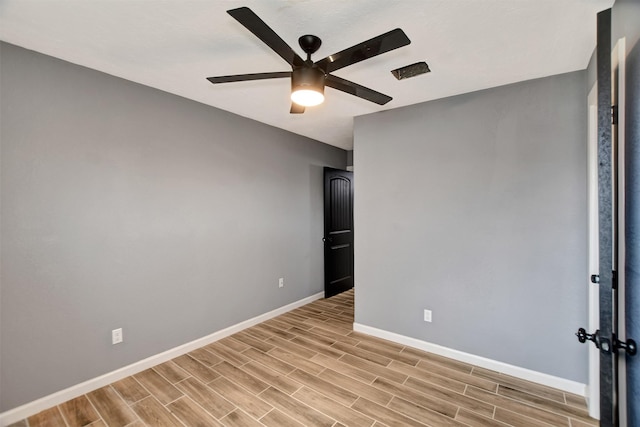 unfurnished room featuring a ceiling fan, wood finish floors, and baseboards