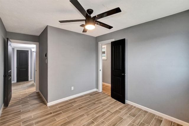 spare room with baseboards, a ceiling fan, and wood finish floors