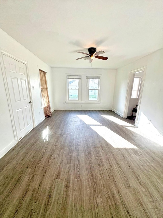 spare room with plenty of natural light, wood finished floors, and baseboards