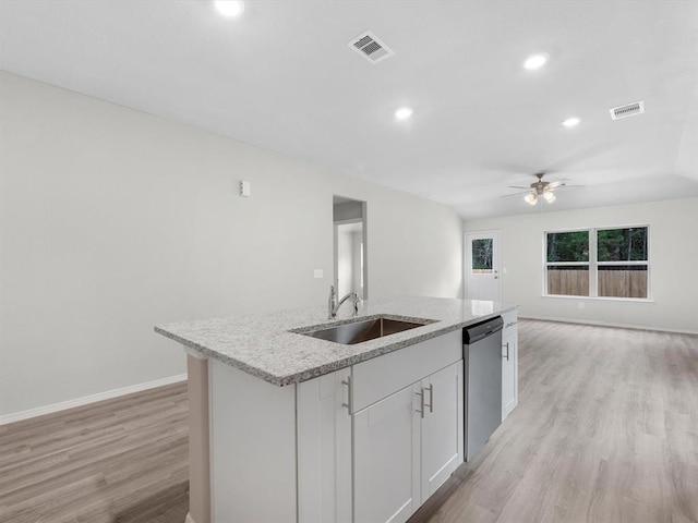 kitchen featuring visible vents, stainless steel dishwasher, open floor plan, a kitchen island with sink, and a sink