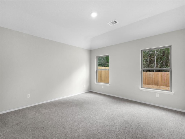 spare room featuring carpet, visible vents, and baseboards