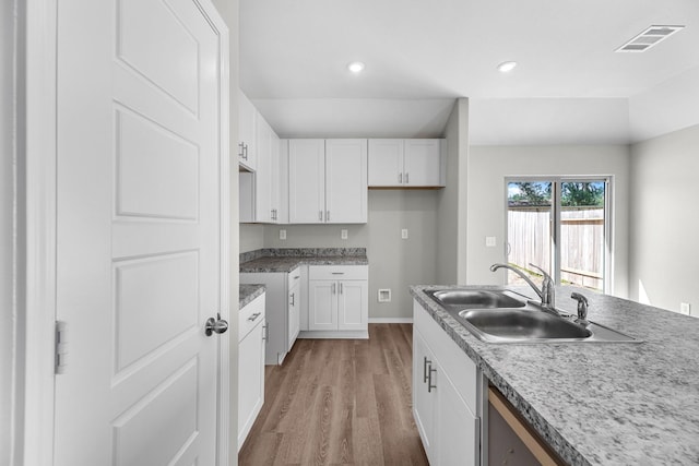 kitchen with visible vents, wood finished floors, white cabinetry, a sink, and recessed lighting