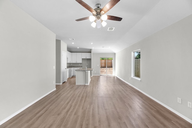 unfurnished living room featuring light wood finished floors, visible vents, baseboards, a ceiling fan, and recessed lighting