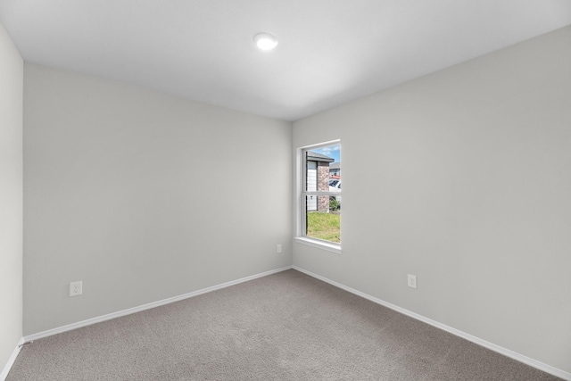 carpeted spare room featuring baseboards