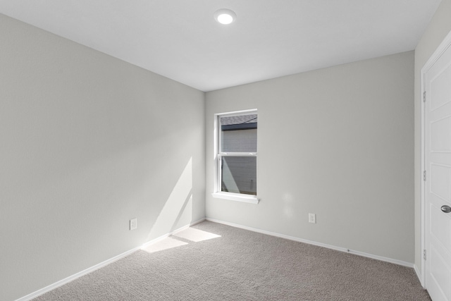 spare room featuring baseboards and carpet flooring