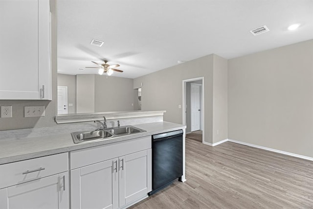 kitchen featuring dishwasher, light countertops, a sink, and visible vents