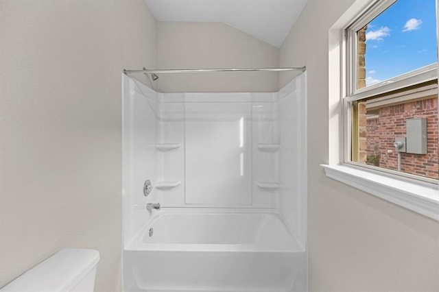 bathroom with shower / bath combination, vaulted ceiling, and toilet