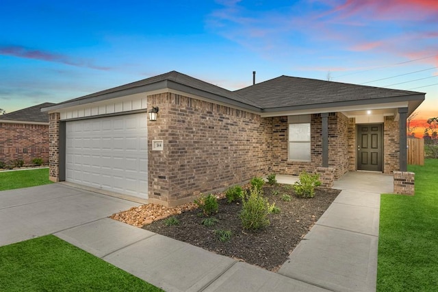 ranch-style house with an attached garage, brick siding, a shingled roof, a yard, and concrete driveway