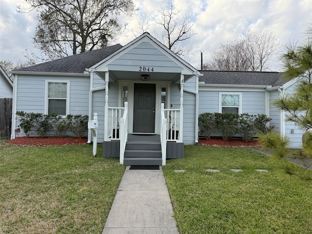 view of front of home featuring a shingled roof and a front yard