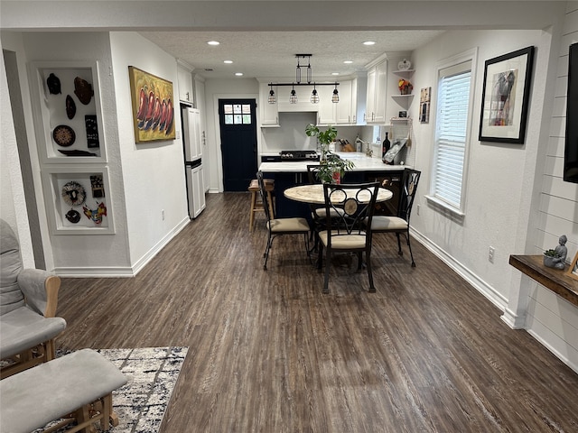 dining area featuring a textured ceiling, baseboards, dark wood-style flooring, and recessed lighting