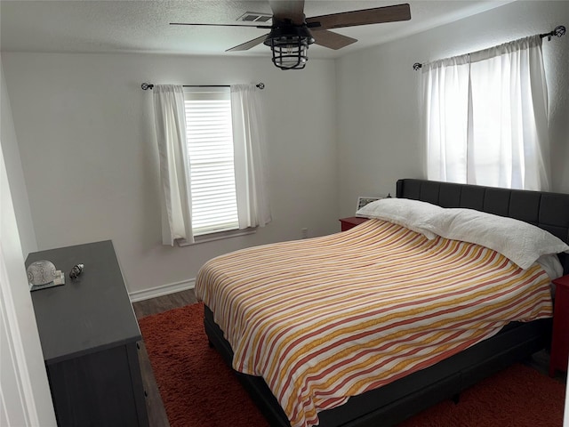 bedroom with ceiling fan, visible vents, and a textured ceiling