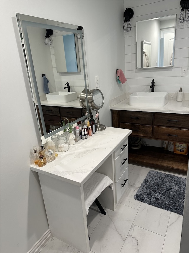 bathroom featuring marble finish floor, two vanities, and a sink