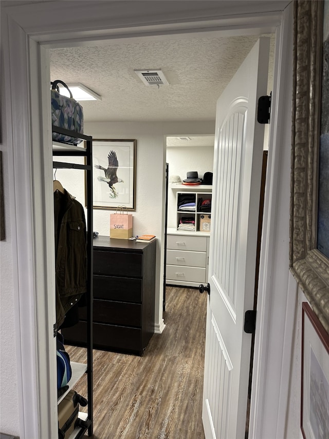 spacious closet featuring dark wood-style flooring and visible vents