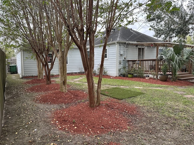 view of home's exterior featuring a shingled roof, a lawn, and a wooden deck