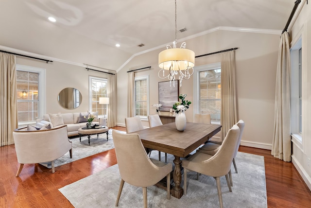 dining area featuring ornamental molding, visible vents, vaulted ceiling, and wood finished floors