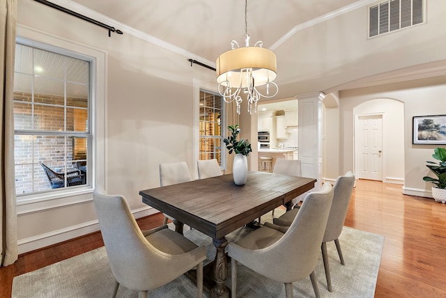 dining area with light wood finished floors, baseboards, visible vents, and ornamental molding