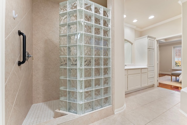 bathroom featuring tile patterned flooring, crown molding, vanity, a walk in shower, and recessed lighting